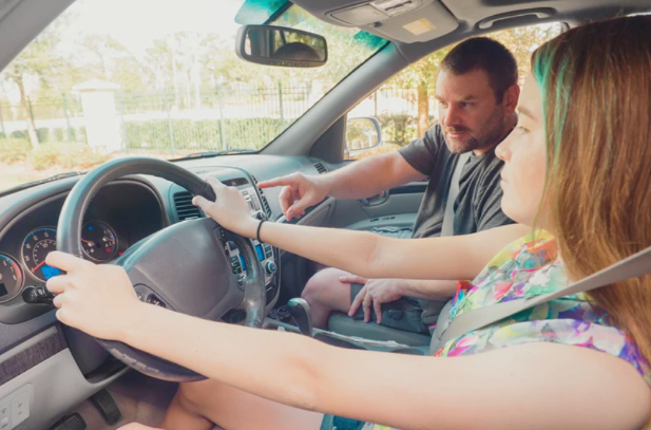 Parent in the passenger seat with their teen driving the car